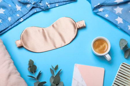 Flat lay composition with sleeping mask on light blue background. Bedtime accessoriesの写真素材