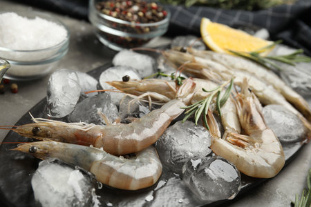 Raw shrimps with ice on gray table, closeupの写真素材