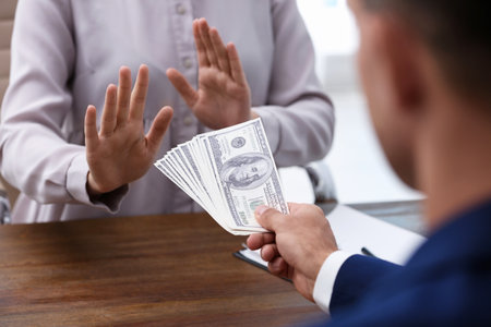 Woman refuses to take bribe money at wooden table, closeupの写真素材