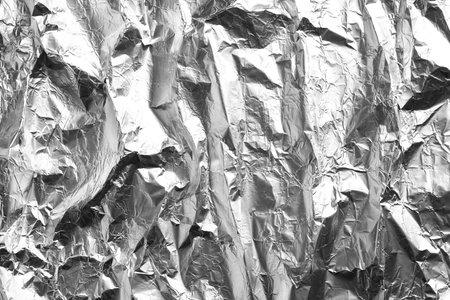 Crumpled silver foil as background, closeup viewの写真素材