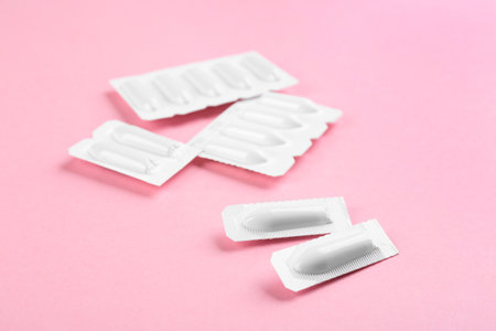 Suppositories on pink background, closeup view. Hemorrhoid treatmentの写真素材
