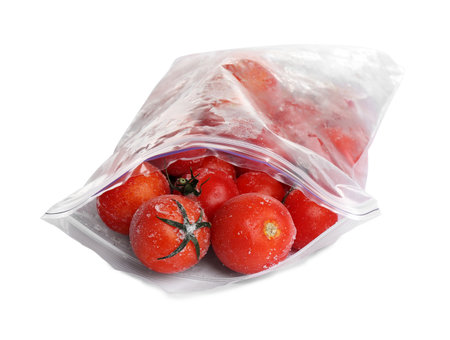 Frozen tomatoes in plastic bag isolated on white. vegetable preservationの写真素材