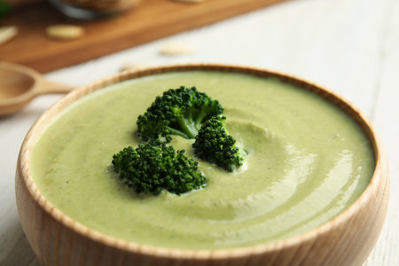 Wooden bowl of delicious broccoli cream soup on table, closeupの写真素材