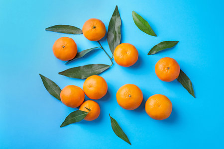 Fresh ripe tangerines on light blue background, flat layの写真素材