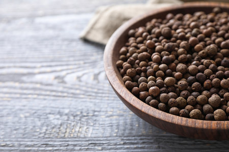Peppercorns on light gray wooden table, closeup