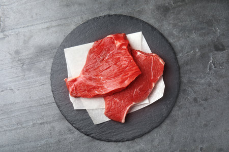 Fresh raw beef cut on gray table, top view