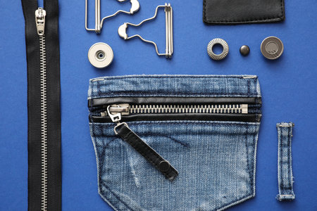 Flat lay composition with garment accessories and cutting details for jeans on blue backgroundの写真素材