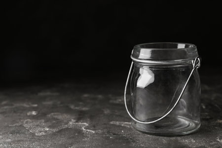 Empty glass jar on gray stone table, space for textの写真素材