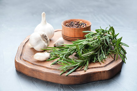 Fresh rosemary, garlic and pepper on gray tableの写真素材