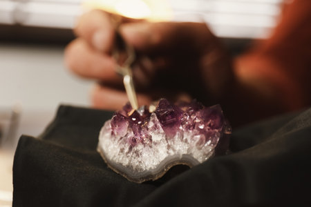 Professional jeweler working with beautiful amethyst indoors, closeupの写真素材
