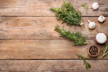 Flat lay composition with fresh rosemary on wooden table. Space for textの写真素材
