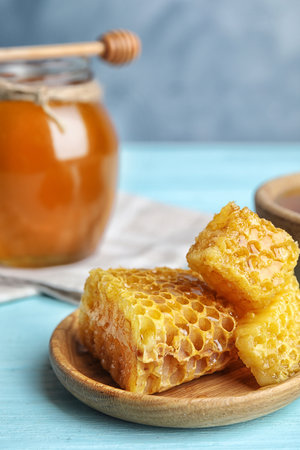 Fresh delicious honeycombs on light blue wooden table, closeupの写真素材