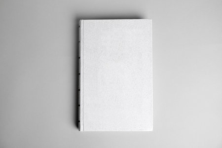Hardcover book on light gray background, top view. space for designの写真素材