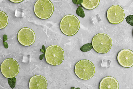 Flat lay composition with slices of fresh juicy limes on marble tableの写真素材
