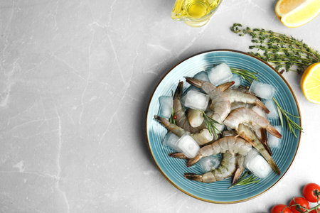Flat lay composition with fresh raw shrimps on light gray marble table. Space for textの写真素材