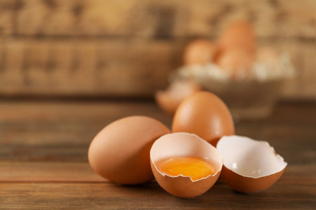 Raw brown chicken eggs on wooden table. Space for text