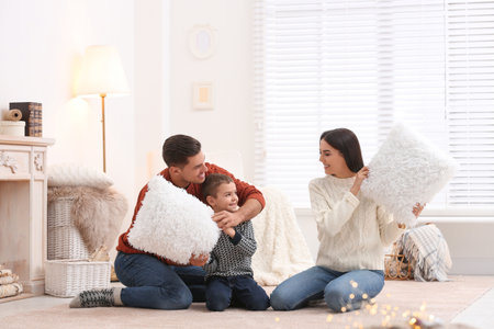 Happy family having pillow fight at home. winter holidaysの写真素材