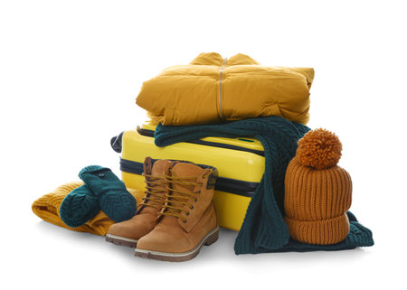 Suitcase with warm clothes isolated on white. winter holidaysの写真素材