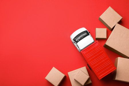 Top view of toy truck with boxes on red background. Logistics and wholesale conceptの写真素材