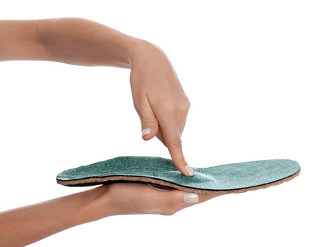 Woman showing orthopedic insole on white background, closeupの写真素材