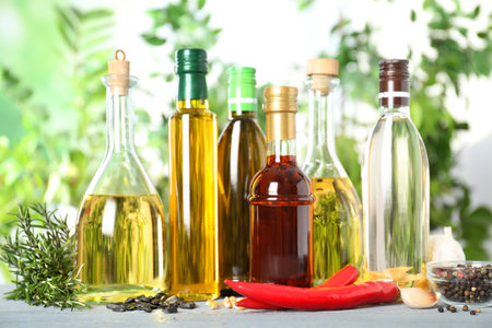 Different sorts of cooking oil in bottles and ingredients on white wooden tableの写真素材