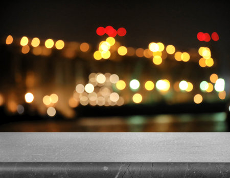 Empty gray marble surface and blurred view of night city. bokeh effect