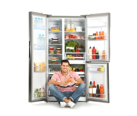 Man near open refrigerator on white backgroundの写真素材