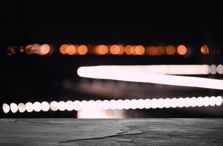 Empty black stone surface and blurred view of night city. bokeh effect