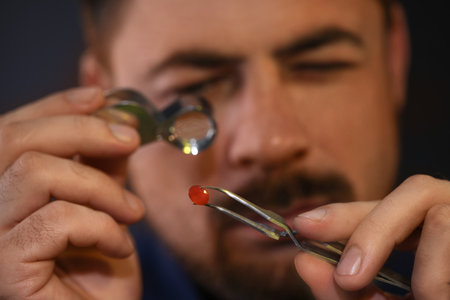 Jeweler working with gemstone on blurred background, closeup