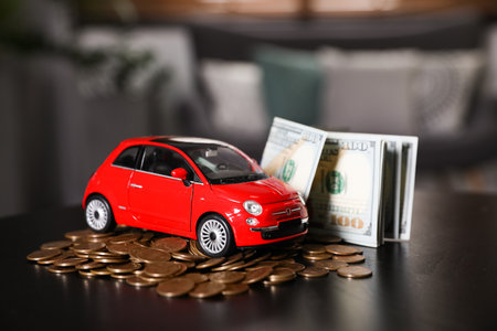 Miniature automobile model and money on table indoors. car buying