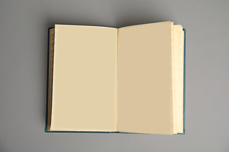 Open book on light gray background, top view. Space for text