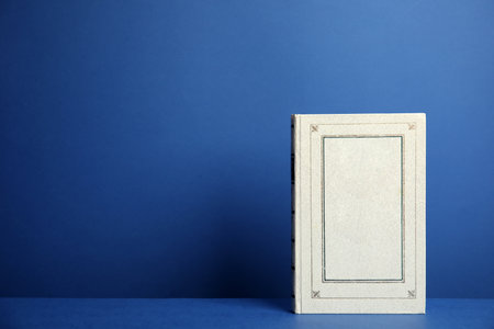 Hardcover book on blue background. space for designの写真素材
