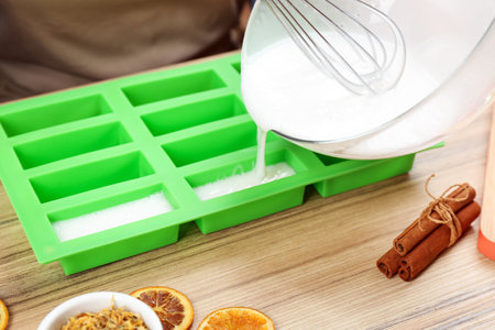 Woman making natural handmade soap at wooden table, closeupの写真素材