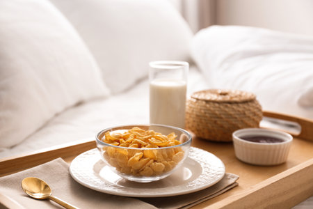 Corn flakes and milk in tray on bed. Delicious morning mealの写真素材