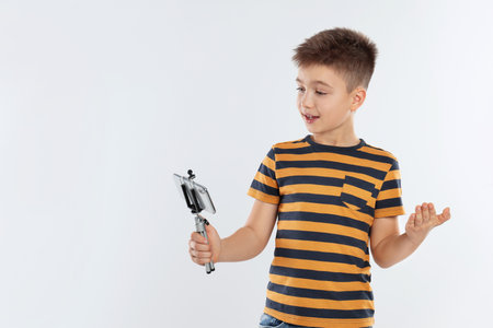 Cute little blogger recording video on white backgroundの写真素材