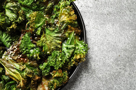 Tasty baked kale chips on gray table, top viewの写真素材