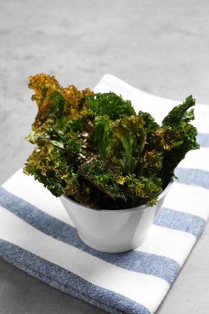 Tasty baked kale chips on gray tableの写真素材
