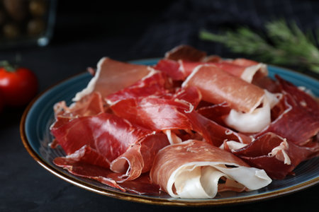 Tasty fresh prosciutto on black table, closeupの写真素材