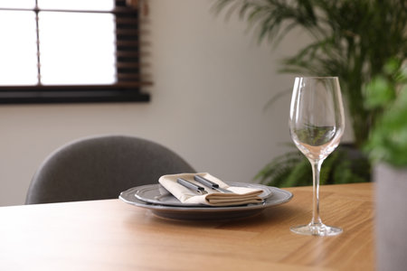Glass and plates on wooden table in dining room
