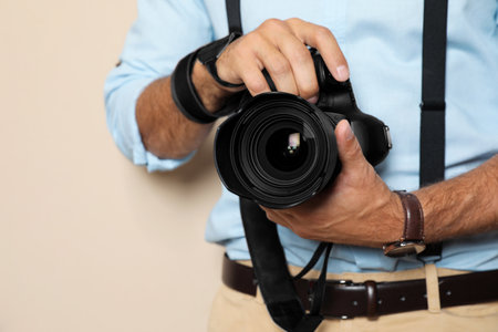 Professional photographer working on beige background in studio, closeupの写真素材