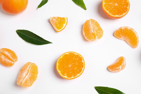 Composition with fresh ripe tangerines and leaves on white background, flat lay. Citrus fruits