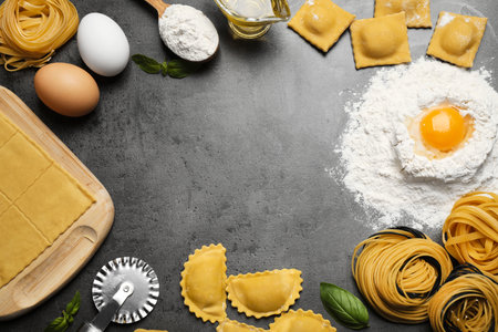 Flat lay composition with different types of pasta on gray table. Space for textの写真素材
