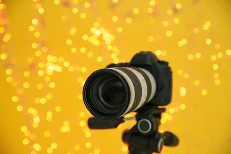 Modern professional video camera against blurred lights
