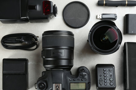 Flat lay composition with equipment for professional photographer on gray marble table