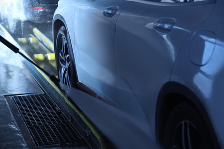 Cleaning auto with high pressure water jet at car wash