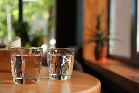 Glasses of water on wooden table in cafe. Space for textの写真素材