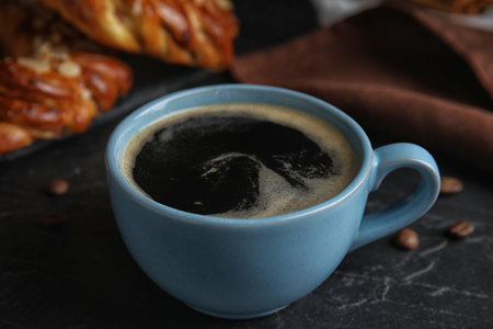 Delicious coffee and pastries on black tableの写真素材