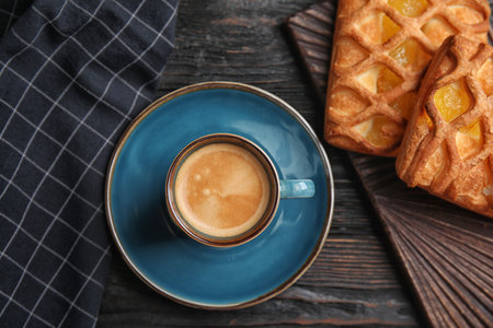Delicious coffee and pastries on black wooden table, flat layの写真素材
