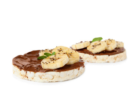 Puffed rice cakes with chocolate spread, banana and mint isolated on whiteの写真素材