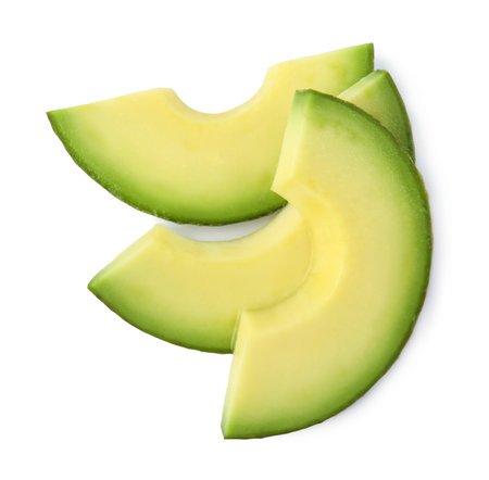 Slices of tasty ripe avocado on white background, top view